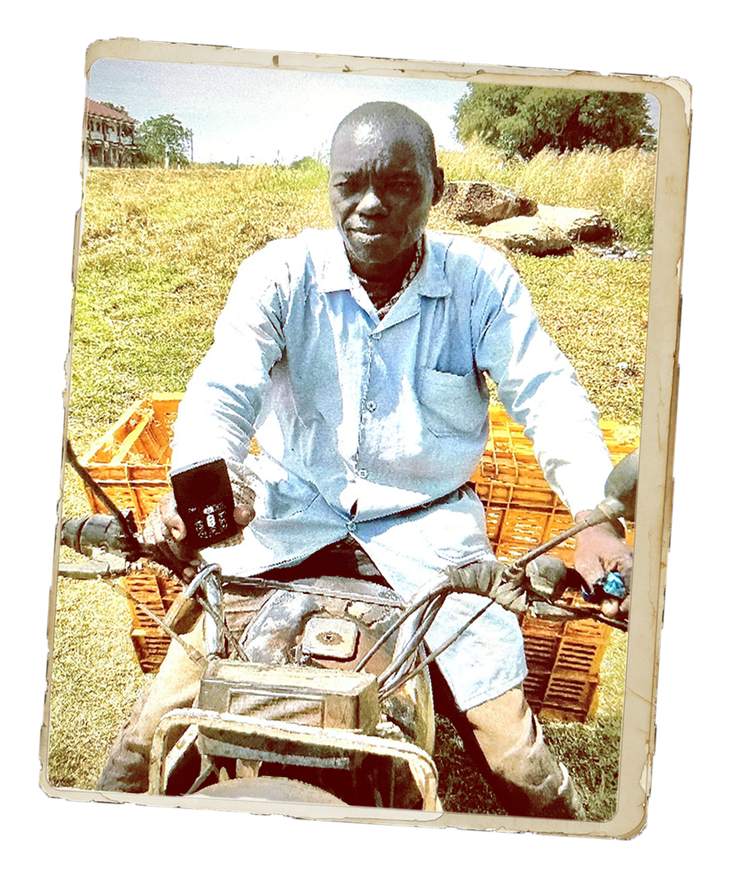 Amari, an egg seller, sits on a motorbike outdoors beside stacked crates, holding a small audio device, representing how he shares Scripture through an Audio Bible as he travels between villages.